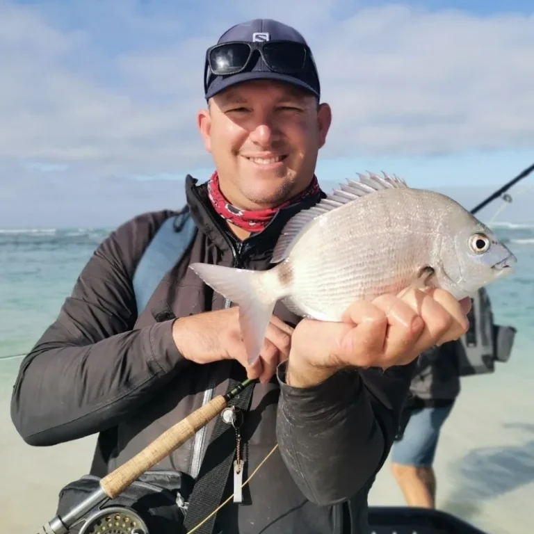 Mark Ascott-Evans holding a fish during an ocean fishing excursion